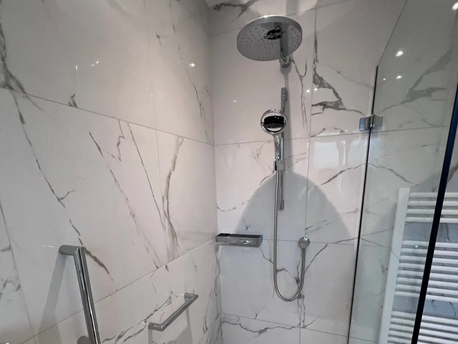 Image showing a renovated shower unit with new tiling, grab bars and thermostatic shower