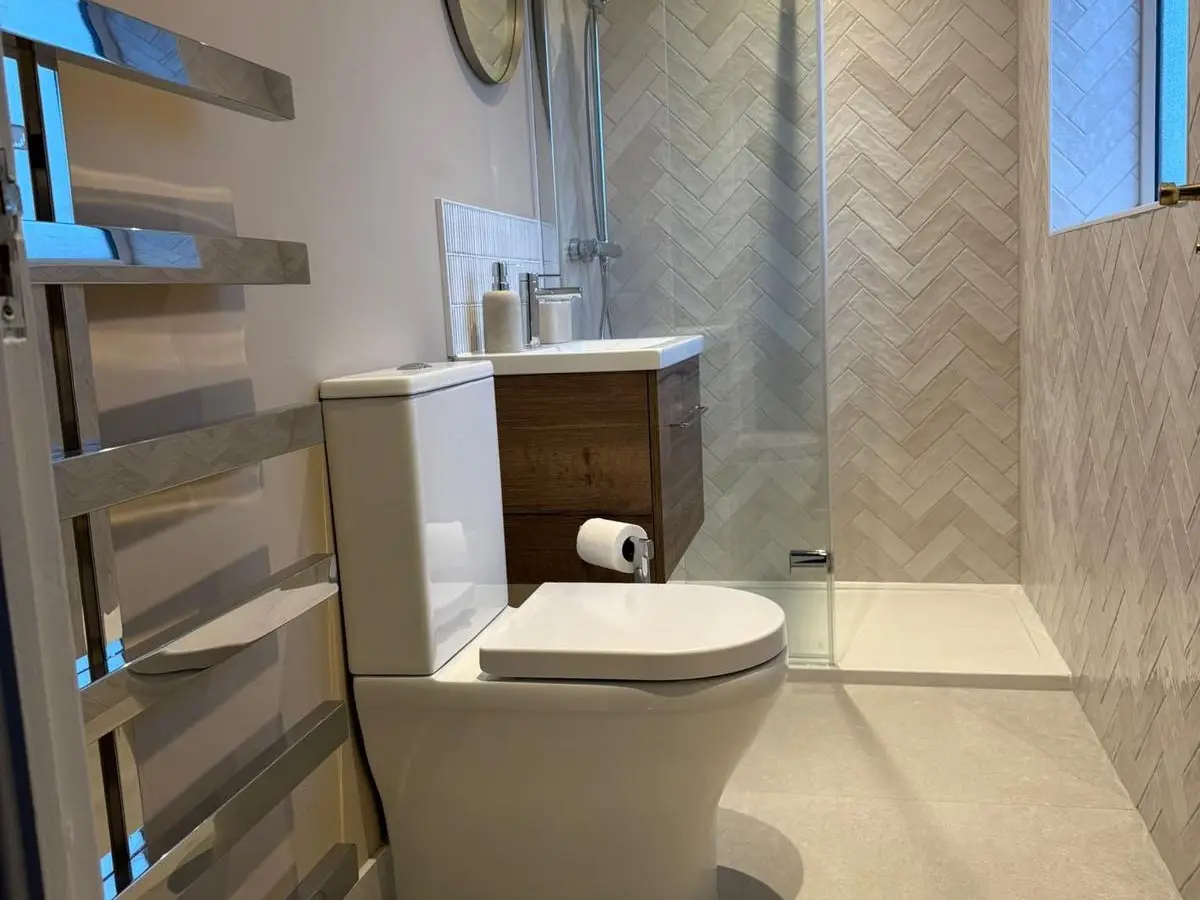Image of a finished newly renovated ensuite shower room using Ca'Pietra tiles, Ambience Bain Vanity unit and Merlyn shower