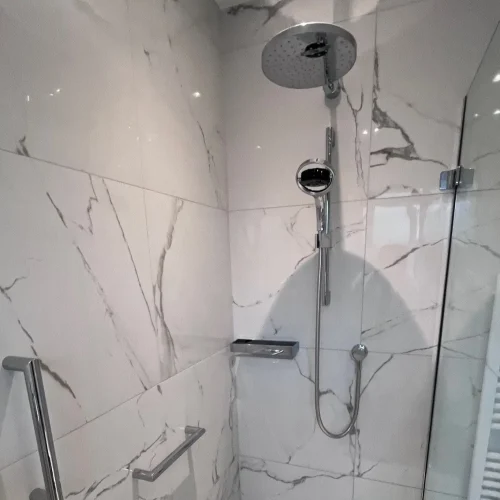 Image showing a renovated shower unit with new tiling, grab bars and thermostatic shower