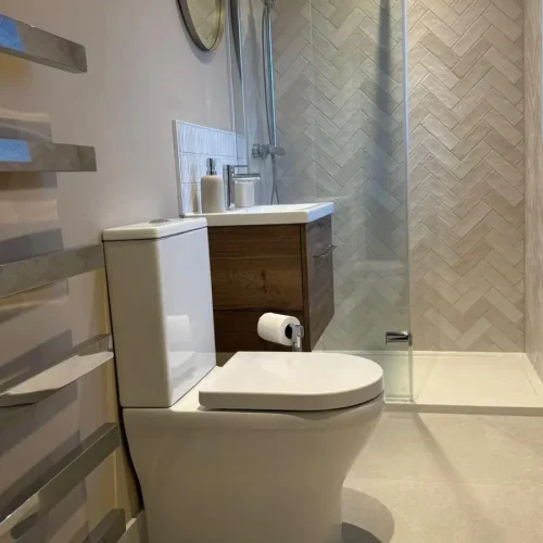 Image of a finished newly renovated ensuite shower room using Ca'Pietra tiles, Ambience Bain Vanity unit and Merlyn shower