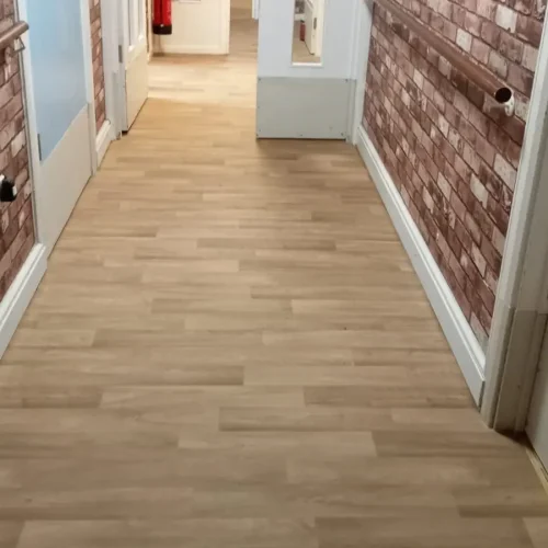 Image of safety flooring in a nursing home, showcasing a non-slip, cushioned surface that minimizes fall risks. The flooring is seamlessly installed in a common area, providing a secure and comfortable environment for elderly residents to move around safely.